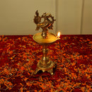 Brass peacock parrot Diya - exquisitely crafted brass oil lamp in the shape of a peacock with parrot motifs, golden finish, decorative home accent, fusion of elegance and vibrancy, traditional Indian Diya, emits a captivating and auspicious glow, perfect for festive occasions and religious ceremonies, enhances spiritual ambiance and decor with a touch of artistic brilliance.