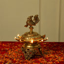 Brass peacock parrot Diya - exquisitely crafted brass oil lamp in the shape of a peacock with parrot motifs, golden finish, decorative home accent, fusion of elegance and vibrancy, traditional Indian Diya, emits a captivating and auspicious glow, perfect for festive occasions and religious ceremonies, enhances spiritual ambiance and decor with a touch of artistic brilliance.