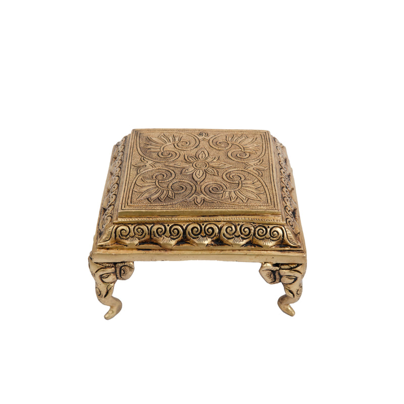 Brass Chowki - intricately carved brass platform, golden finish, perfect for placing deities or sacred objects during religious ceremonies and rituals, enhances the sanctity and beauty of the worship space, symbolizes stability and divine presence, adds a touch of elegance to your home puja setup, a valuable and ornamental addition to your collection of brass religious artifacts and decor.