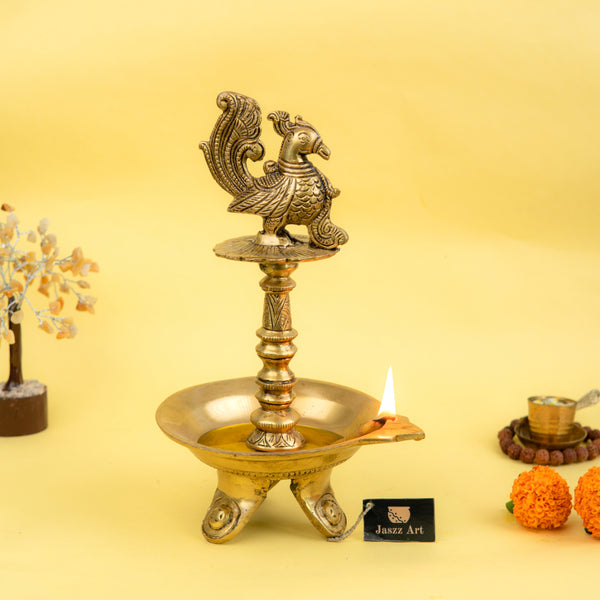 Brass peacock parrot Diya - exquisitely crafted brass oil lamp in the shape of a peacock with parrot motifs, golden finish, decorative home accent, fusion of elegance and vibrancy, traditional Indian Diya, emits a captivating and auspicious glow, perfect for festive occasions and religious ceremonies, enhances spiritual ambiance and decor with a touch of artistic brilliance.